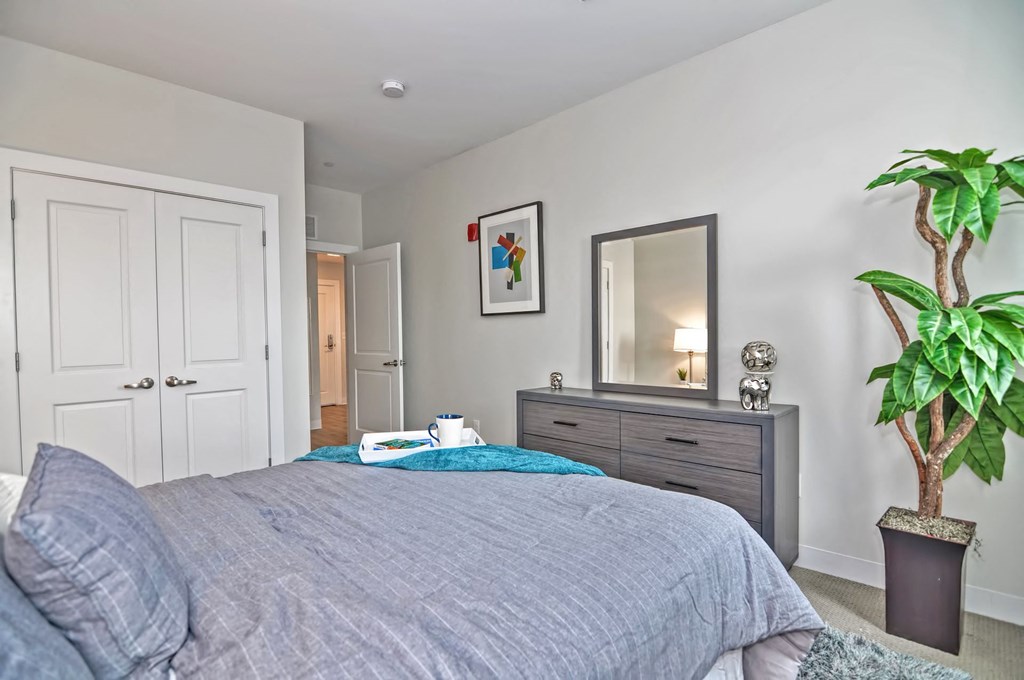 a bedroom with a bed and a dresser and a mirror