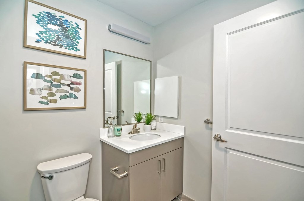 a bathroom with a toilet sink and a mirror