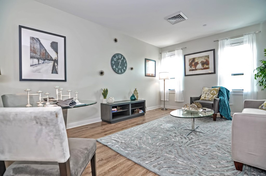 a living room with white furniture and a rug