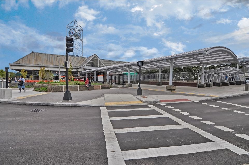 an empty street in front of an airport with a large building