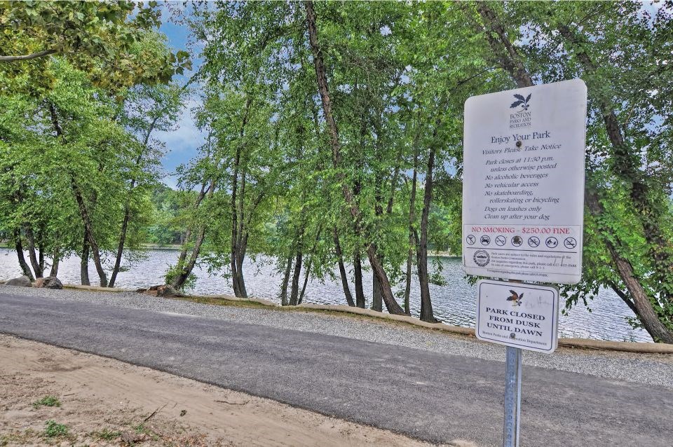 a sign on the side of a road next to a river