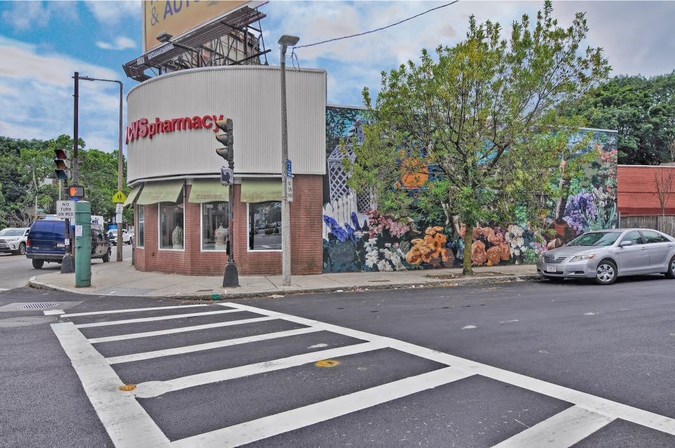 the corner of a street with a building and a car on it