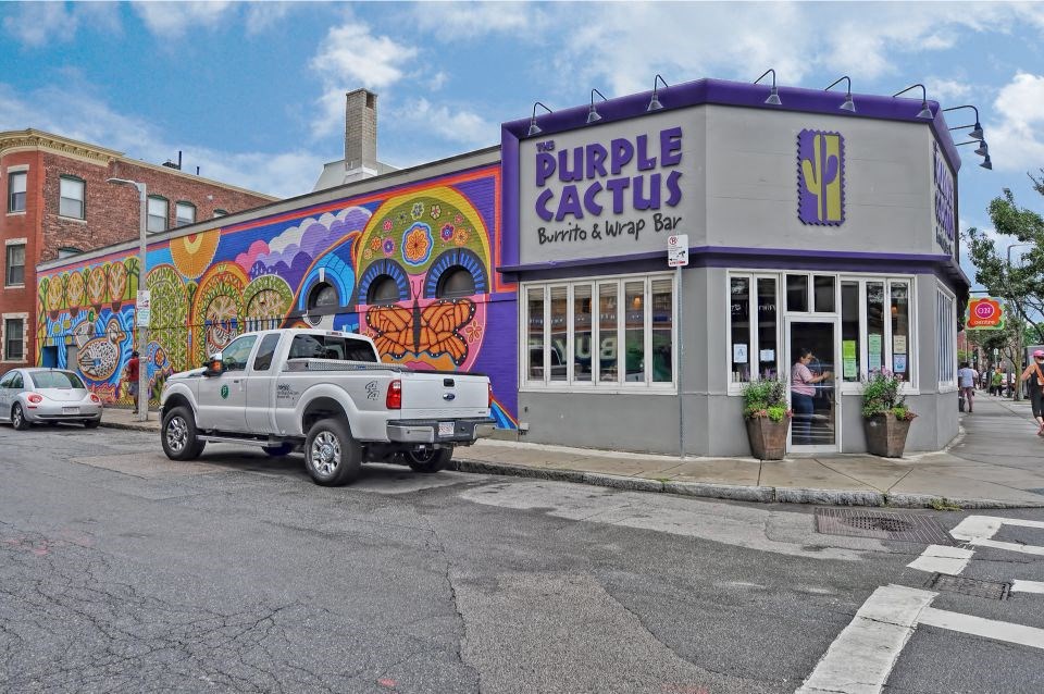 a truck parked in front of a building with a colorful mural