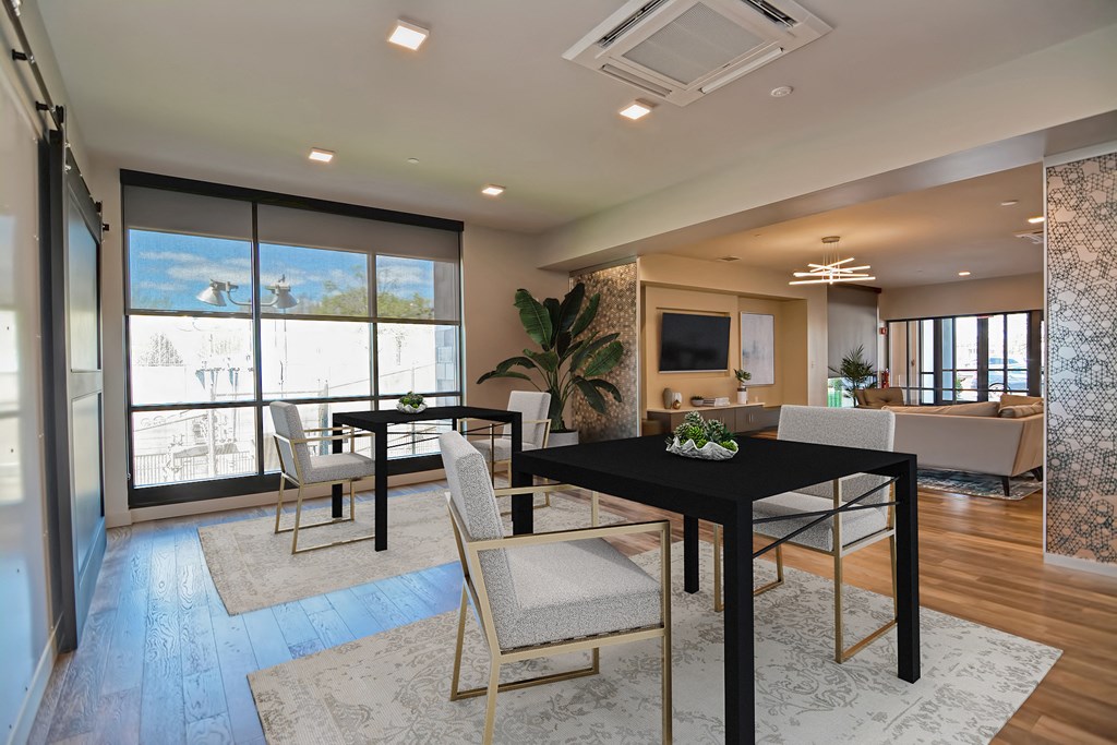a dining room with a black table and white chairs