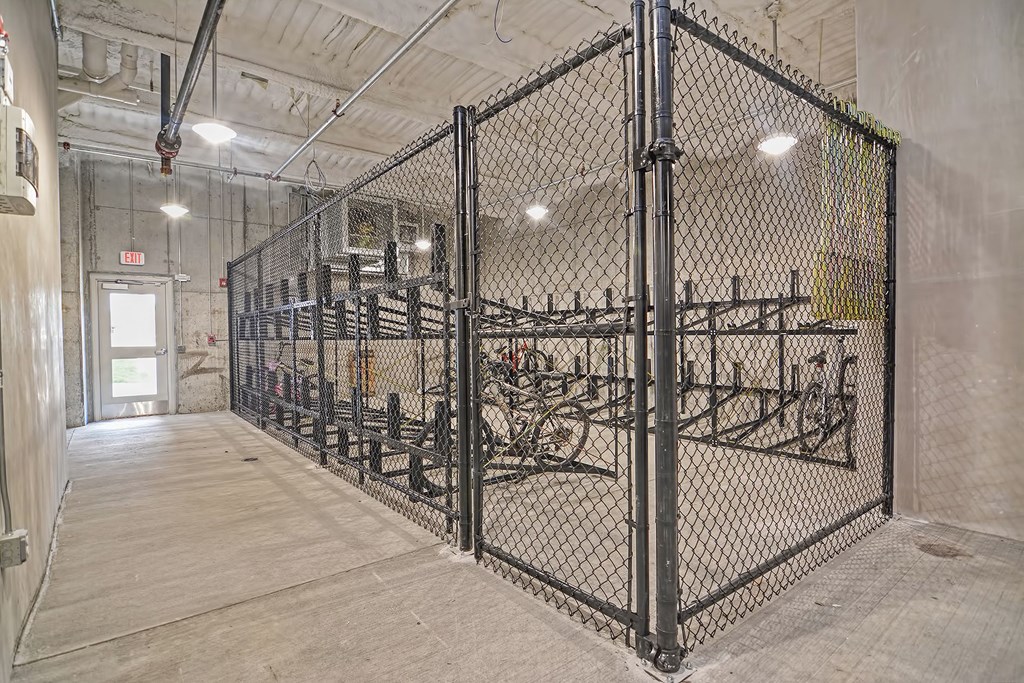 the inside of a gym with a chain link fence and bikes in it