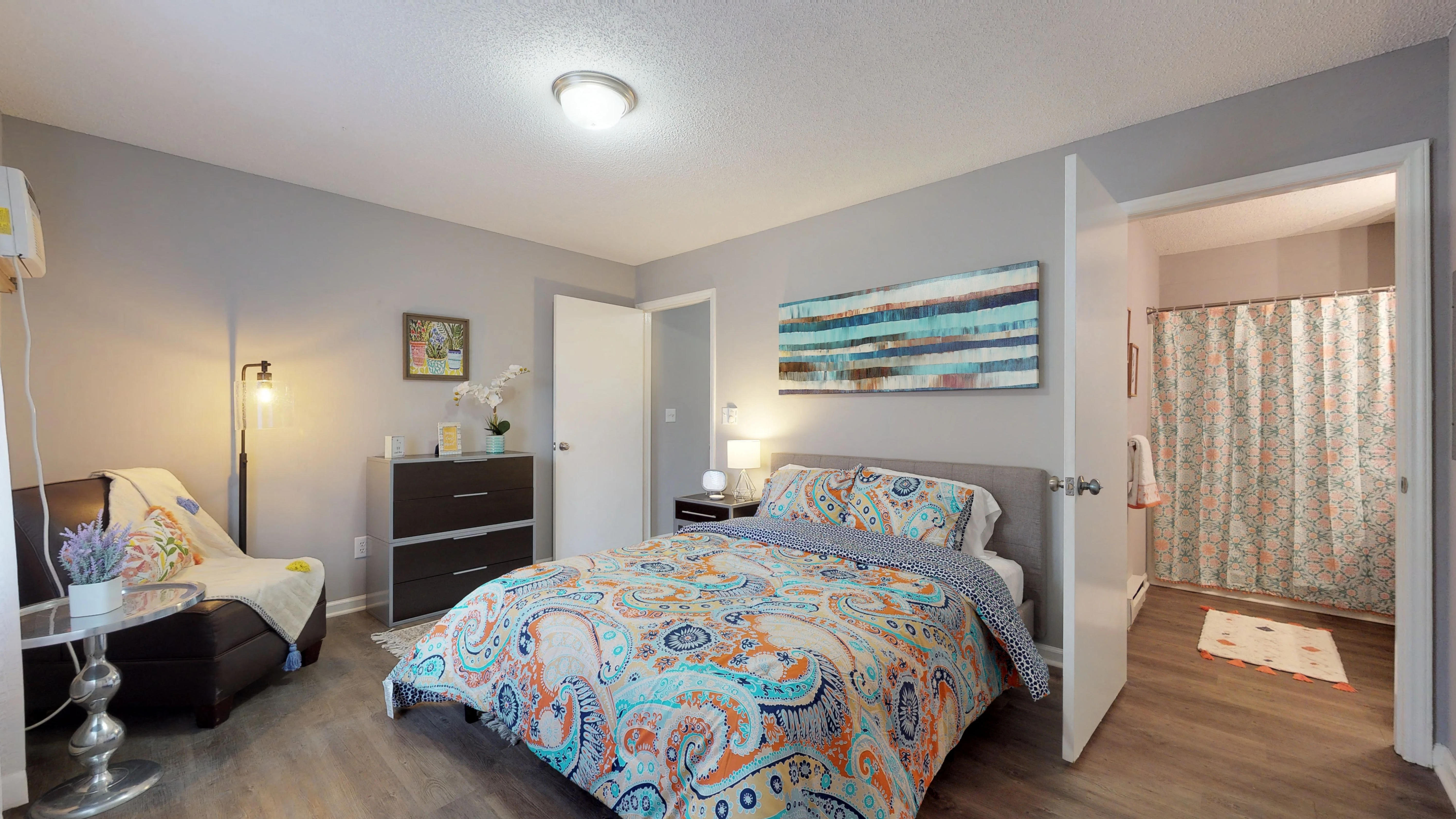 A bedroom with a large bed and a dresser.