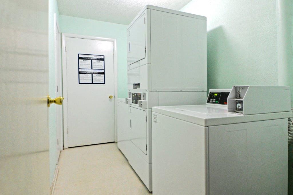 a white kitchen with a refrigerator and a washing machine