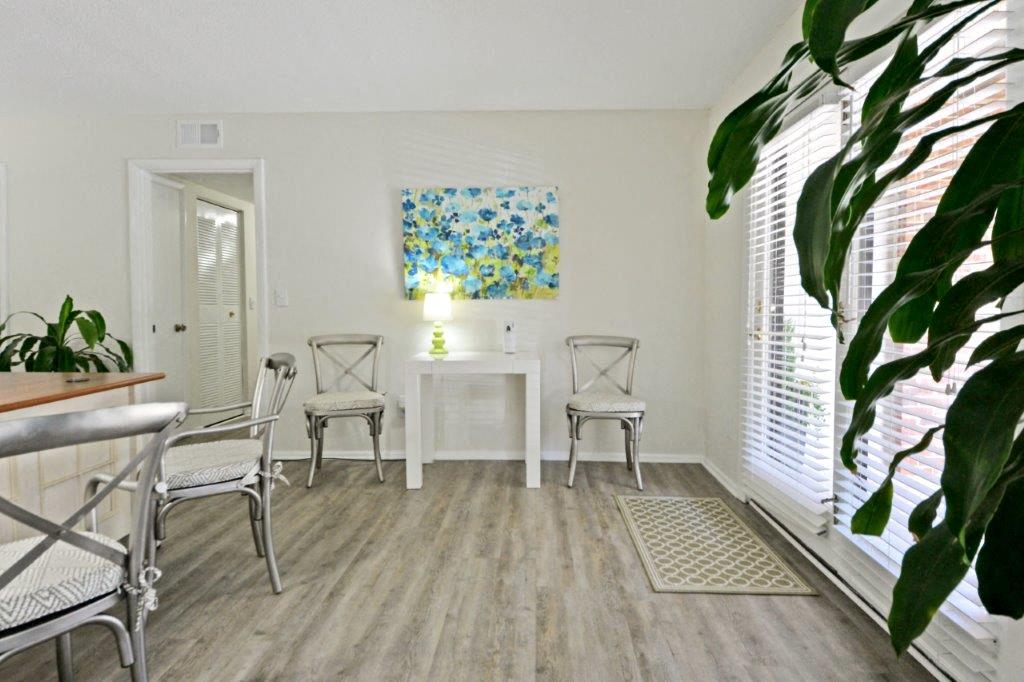 a living room with a table and chairs and a window