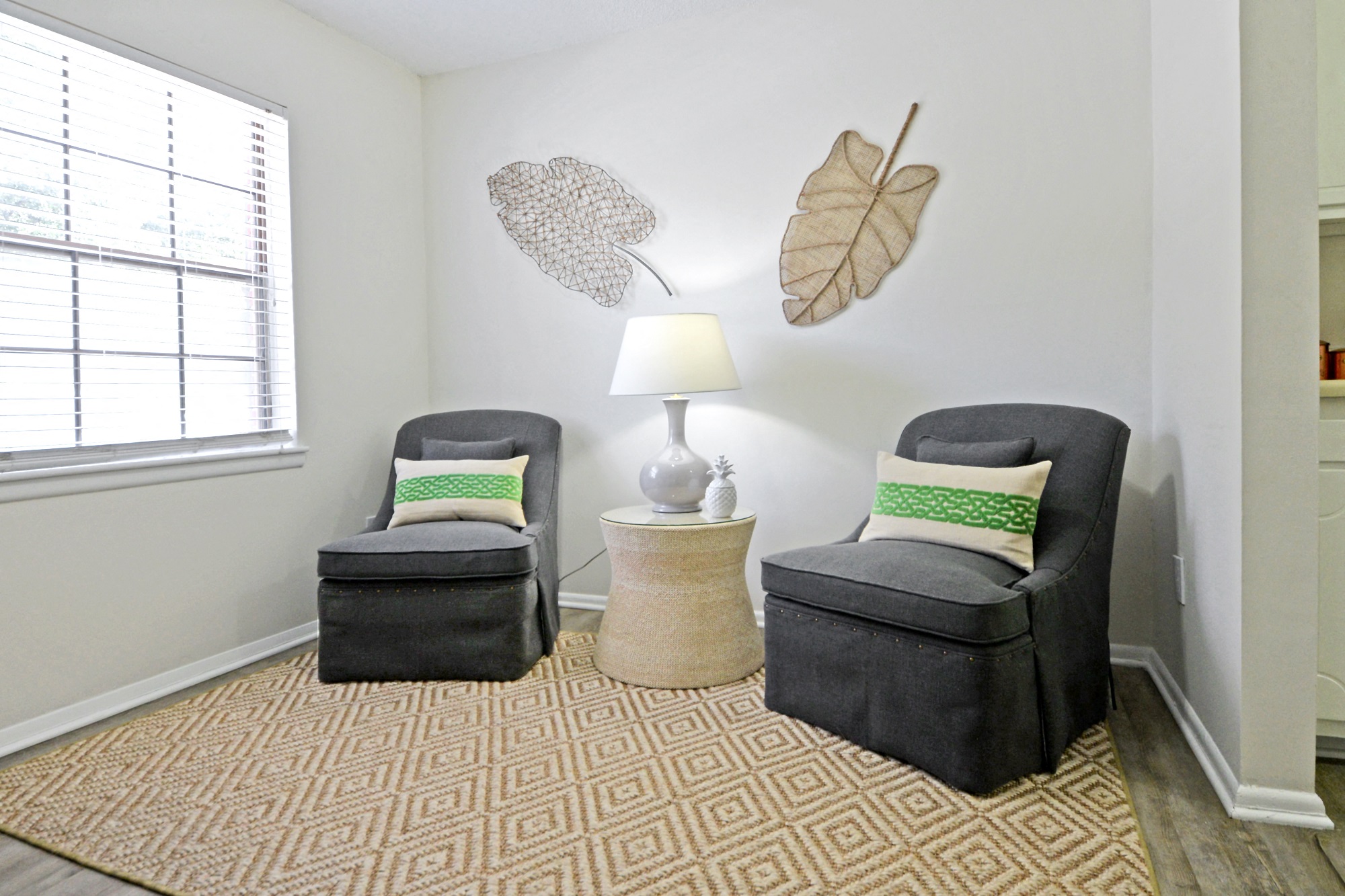 a living room with two chairs and two leaves on the wall