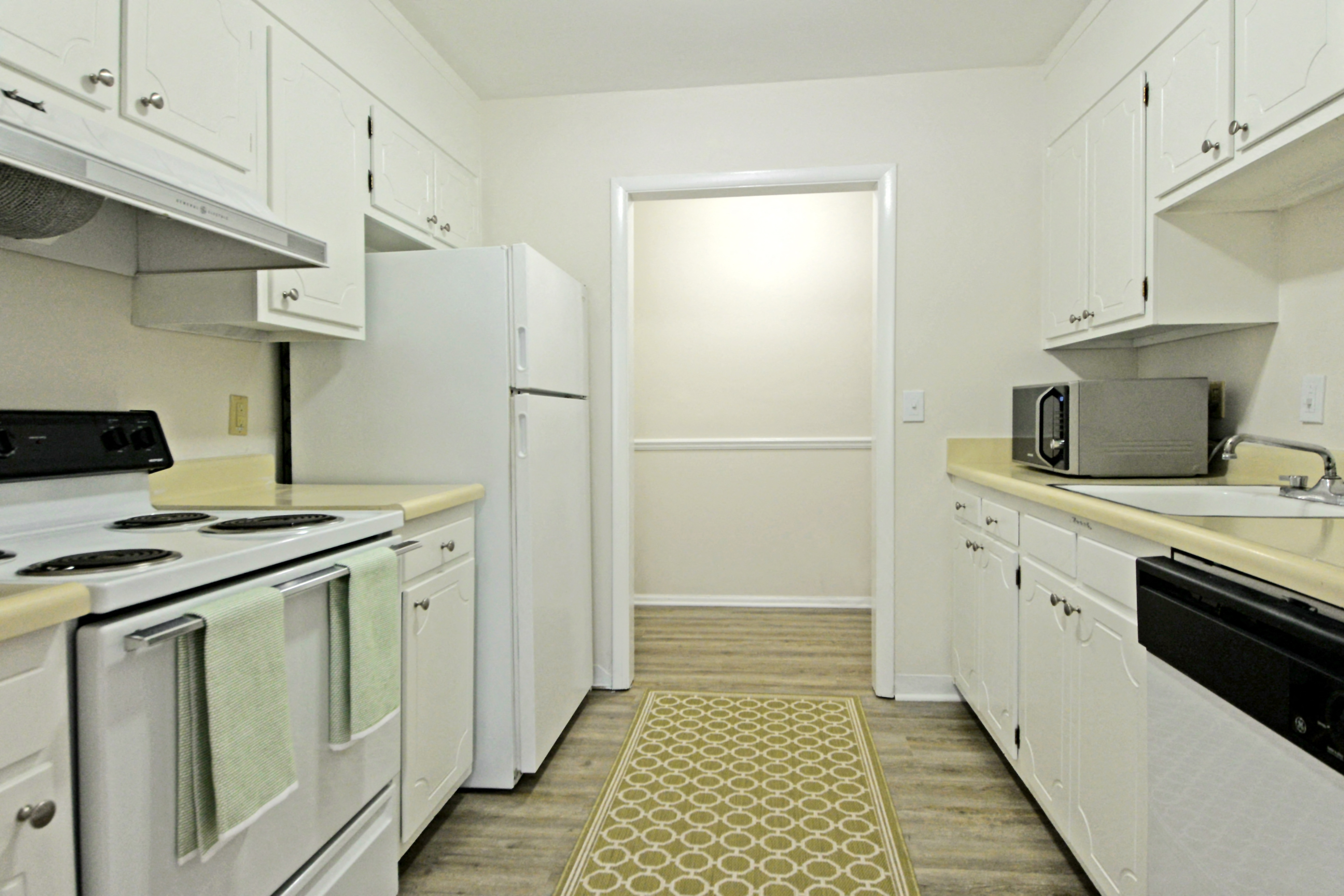 a white kitchen with white appliances and white cabinets