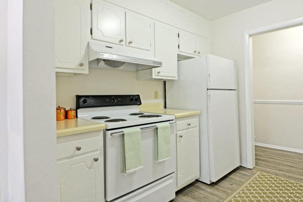 a white kitchen with white appliances and white cabinets