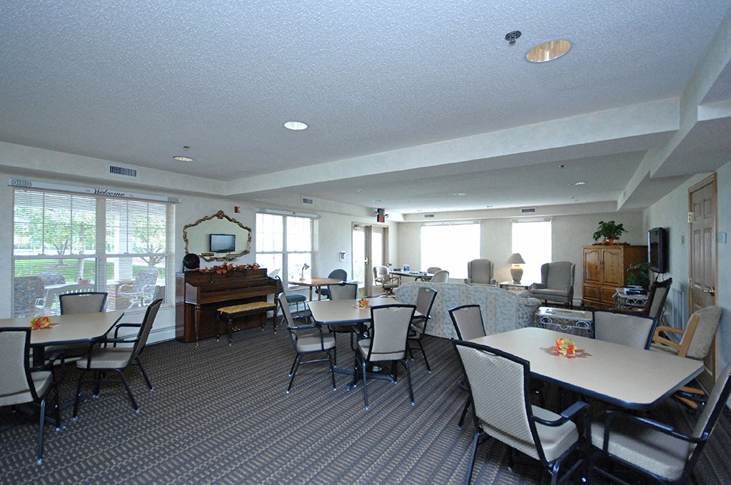 a dining room with tables and chairs and a piano