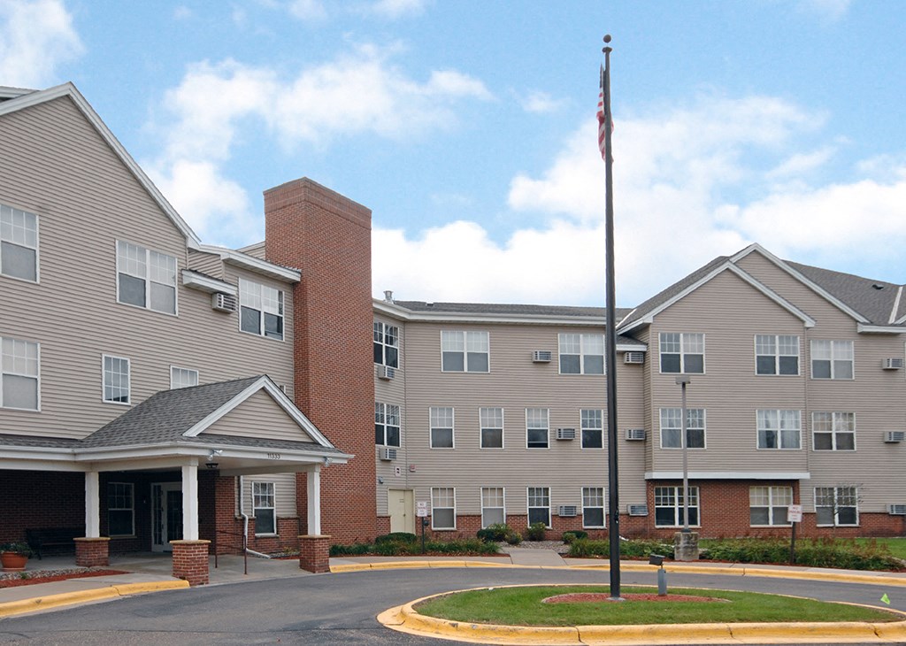 an exterior view of an apartment building with a flagpole