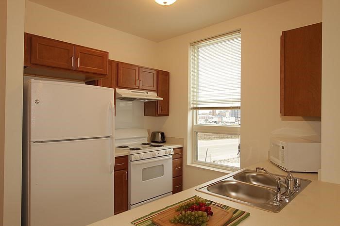 a kitchen with a white refrigerator and a sink