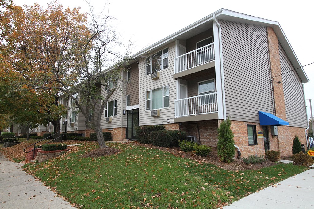 the exterior of an apartment building with a sidewalk