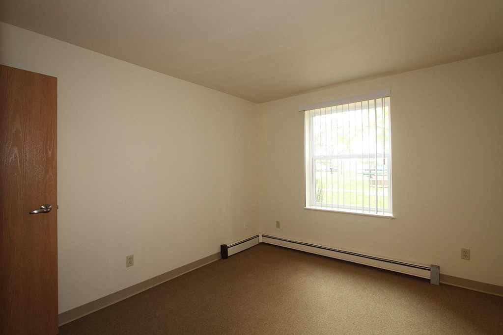 an empty room with a window and a door