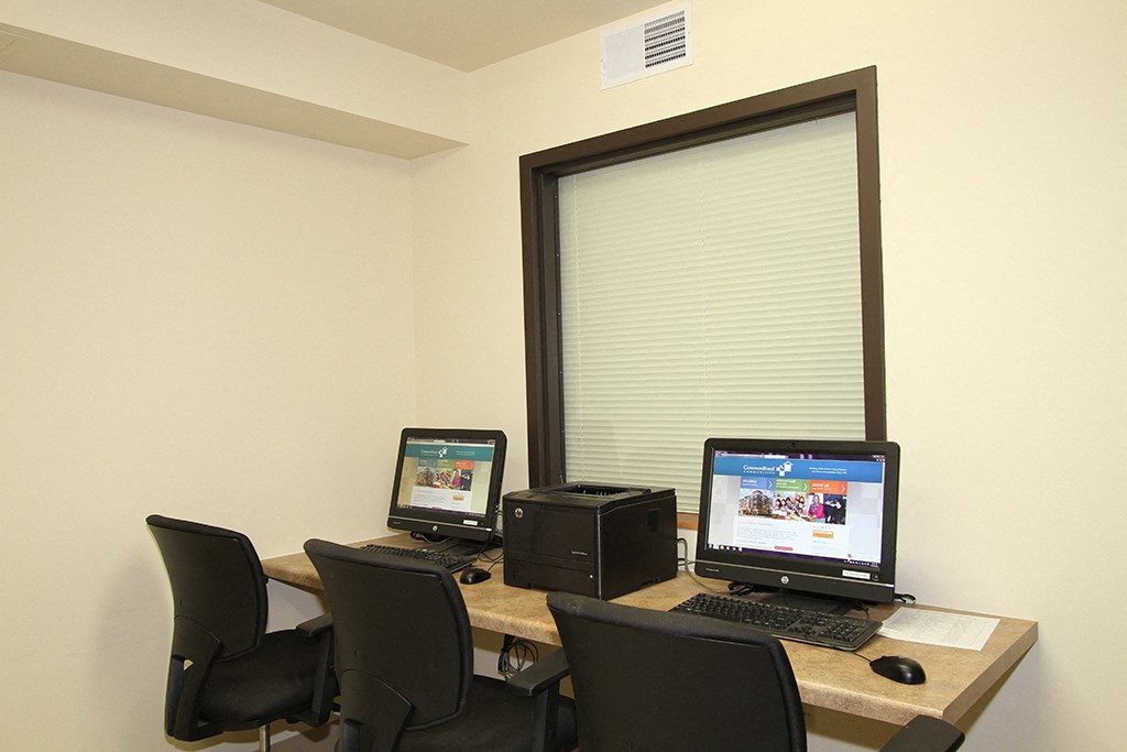 an office with a desk with two computers on it