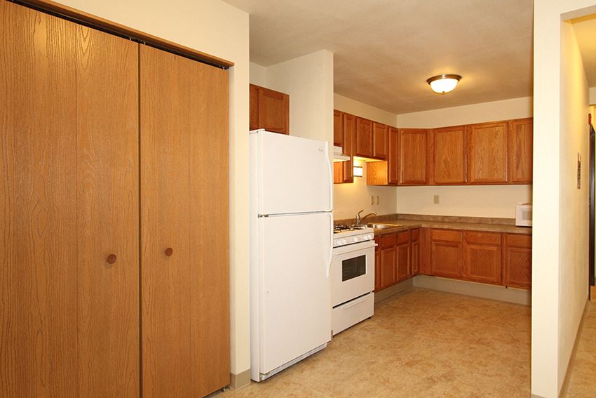 a kitchen with white appliances and wooden cabinets