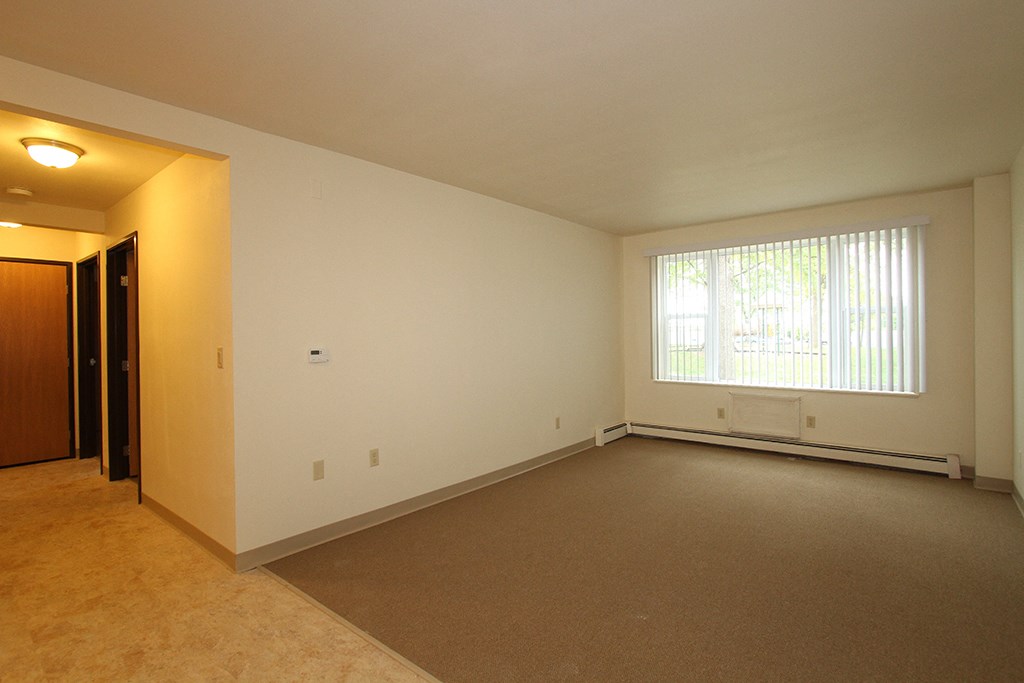 the living room of an empty house with a large window