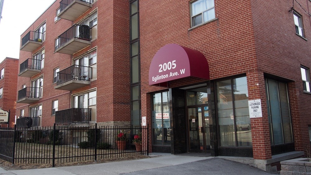 a red brick apartment building with a red sign on the front of it