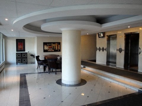 a large lobby with a table and chairs and a pillar