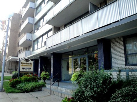 an apartment building with a sign in front of it