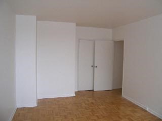 an empty room with white walls and a wood floor