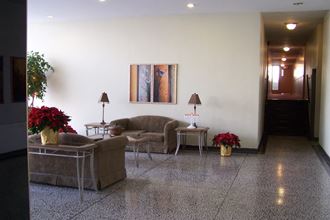 the lobby of a hotel with couches and flowers