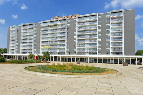 a large apartment building with a courtyard in front of it