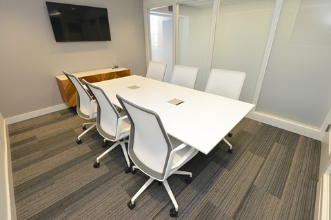 a conference room with a white table and chairs