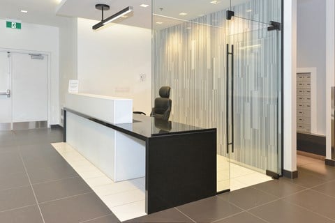 a lobby with a glass shower and a desk with a statue