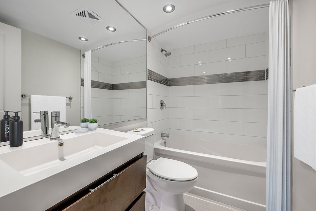 A white bathroom with a toilet, sink, and bathtub.