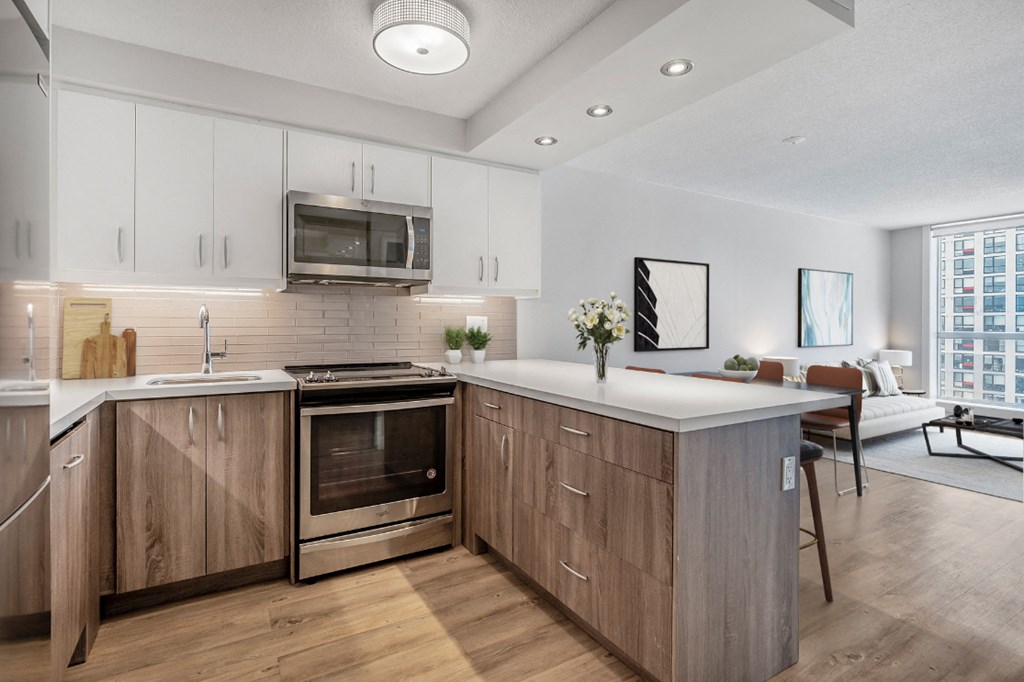 A modern kitchen with wooden cabinets and a stainless steel oven.