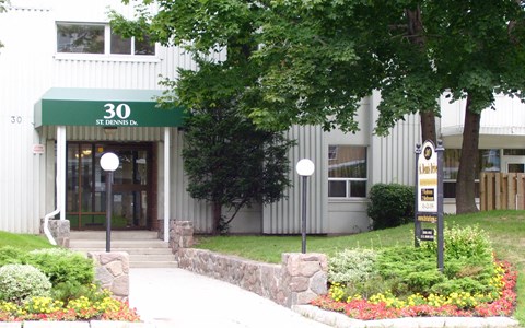 The front of a building with a green awning and the number 30 on it.