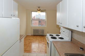 an empty kitchen with white appliances and a window