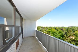 a balcony with a view of trees and a blue sky