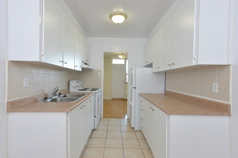 a kitchen with white cabinets and a sink and a refrigerator