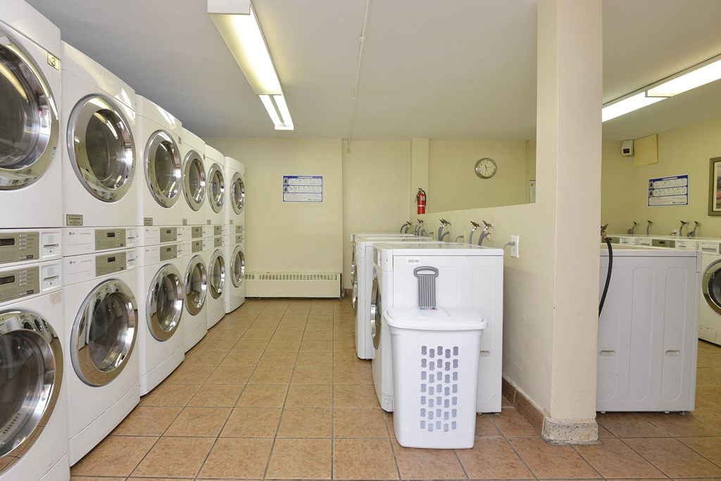 a washer and dryer in a laundry room with a row of washing machines