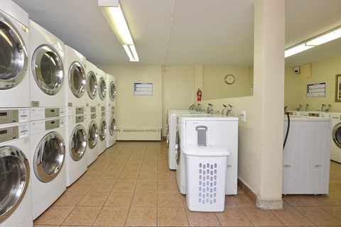 a washer and dryer in a laundry room with a row of washing machines