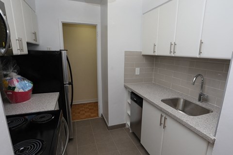 a kitchen with white cabinets and a sink and a refrigerator