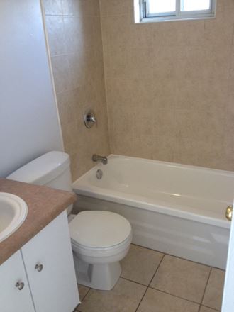 a bathroom with a toilet and a tub and a sink