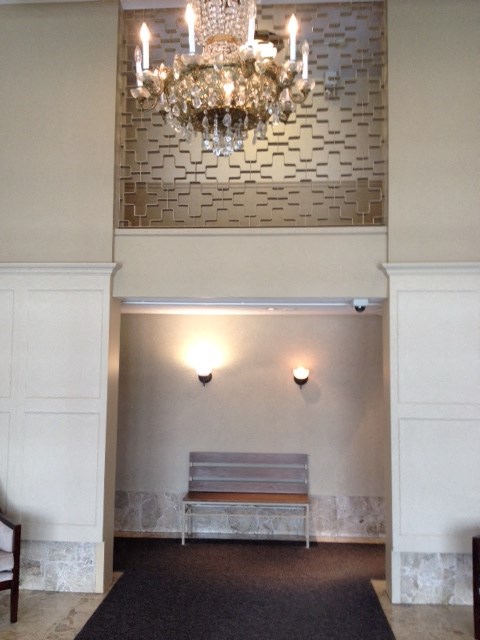 a large empty room with a chandelier and a bench