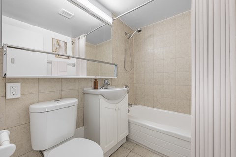 A white toilet sits next to a sink in a bathroom.