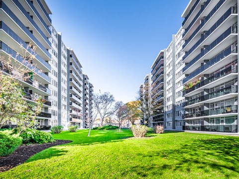 A grassy area in front of two residential buildings.