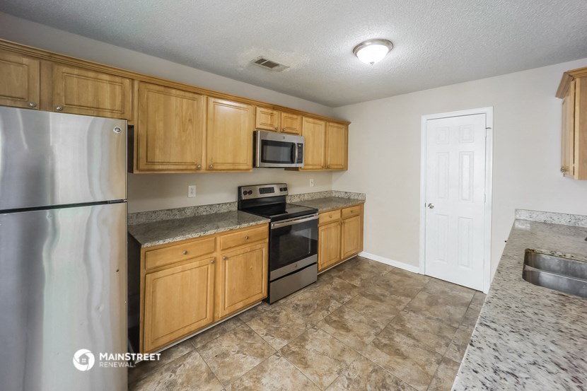 the kitchen of our studio apartment atrium with stainless steel appliances and wooden cabinets
