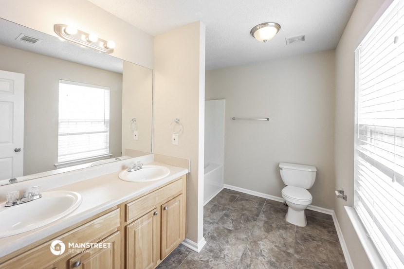 a bathroom with a toilet and a sink and a mirror