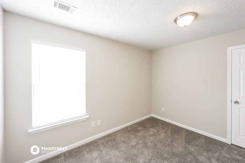 an empty room with a window and a door