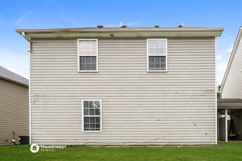 a side view of a white house with white siding
