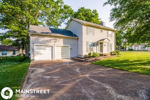 a white house with a garage and a driveway