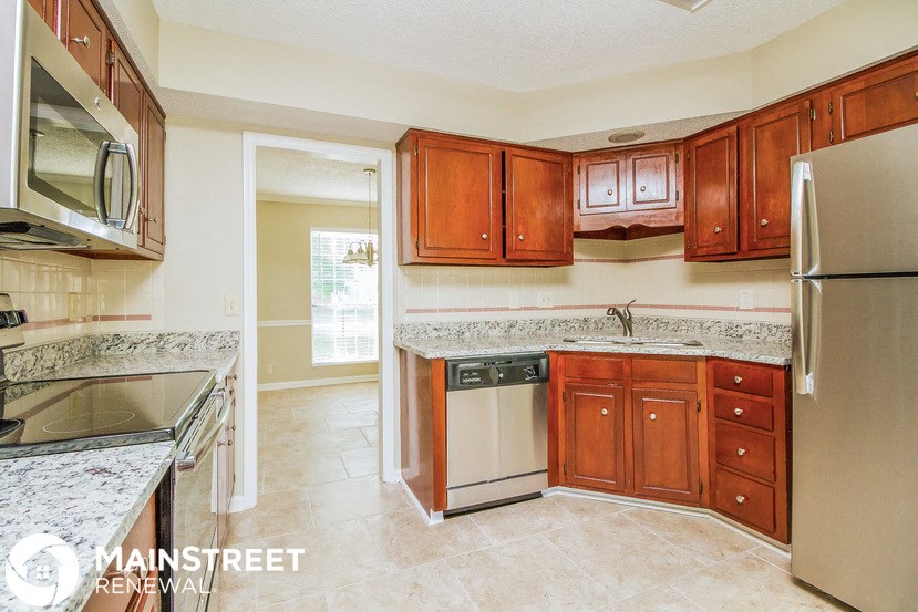 a kitchen with wooden cabinets and stainless steel appliances and granite counter tops